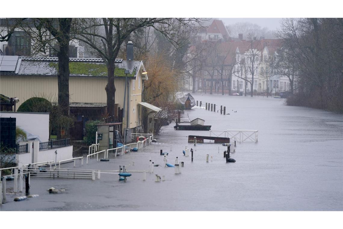 Gehwege und Bootsstege sind am Ufer der Trave in Lübeck vom Hochwasser umgeben.