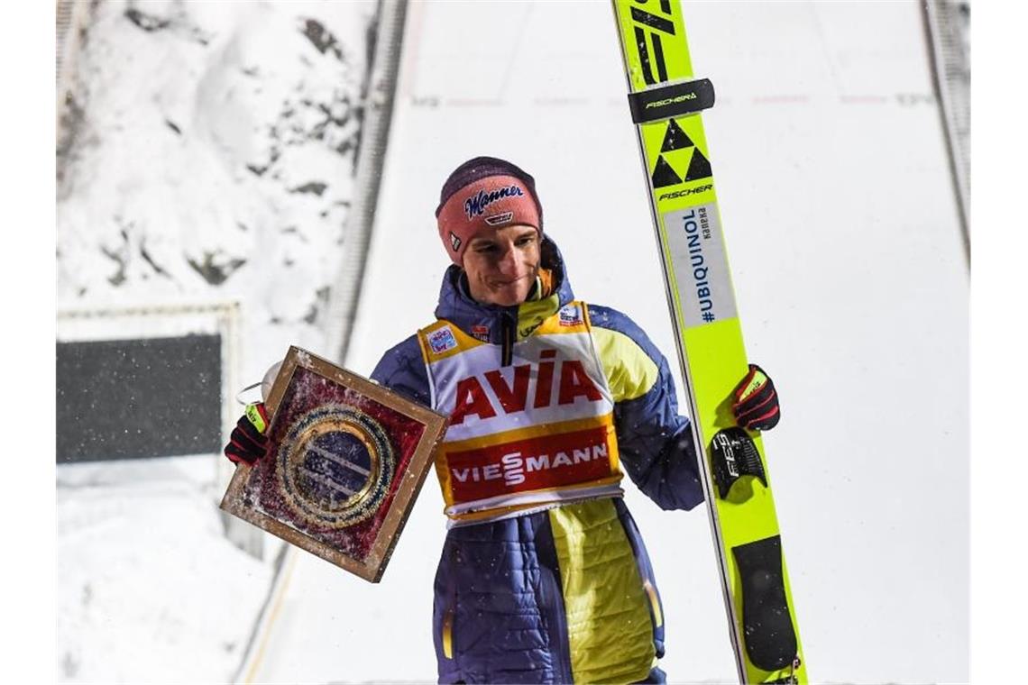 „Gelb trage ich übrigens gerne“: Topeinstand für Geiger Geiger hält eine Trophäe in der Hand. Er hat sein Gelbes Trikot des Weltcup-Gesamtführenden verteidigt. Foto: Tumaschow/NordicFocus/dpa