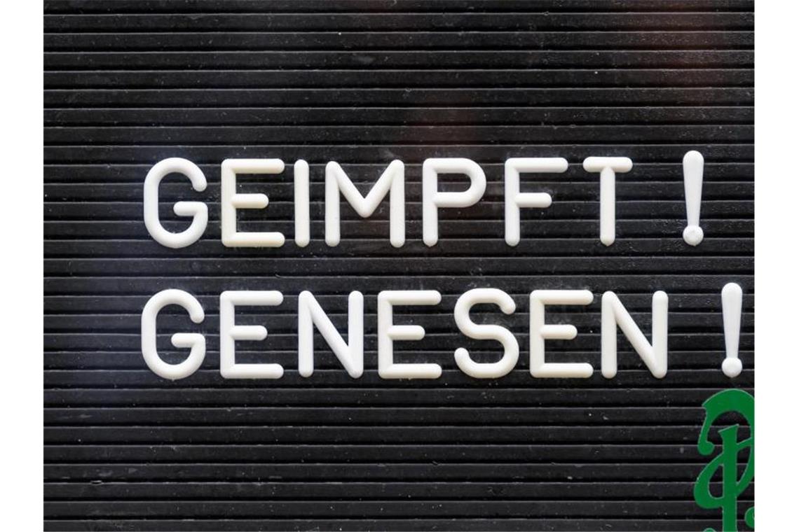 2G-Optionsmodell: Volle Säle und Stadien möglich "Geimpft! Genesen!" steht auf einem Schild an einer Bar. Foto: Robert Michael/dpa-Zentralbild/dpa/Symbolbild