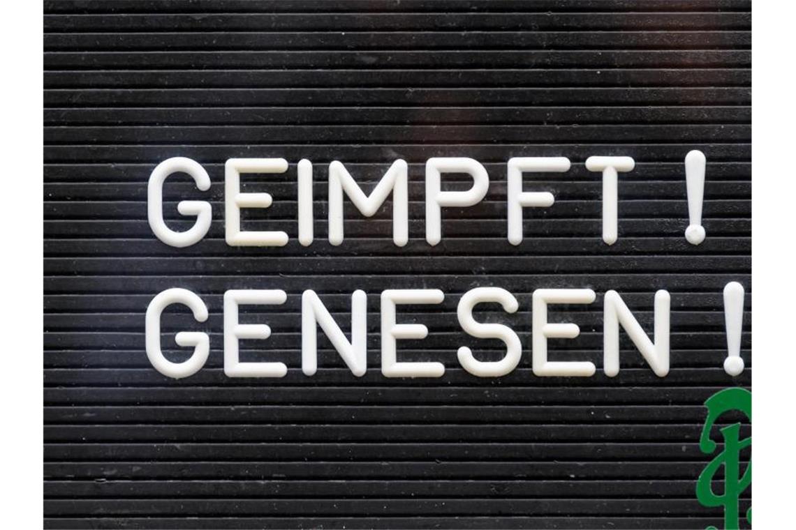 Regierung bleibt bei 2G im Einzelhandel: Wirtschaft drängt „Geimpft! Genesen!“ steht auf einem Schild an einer Bar. Foto: Robert Michael/dpa-Zentralbild/dpa/Symbolbild