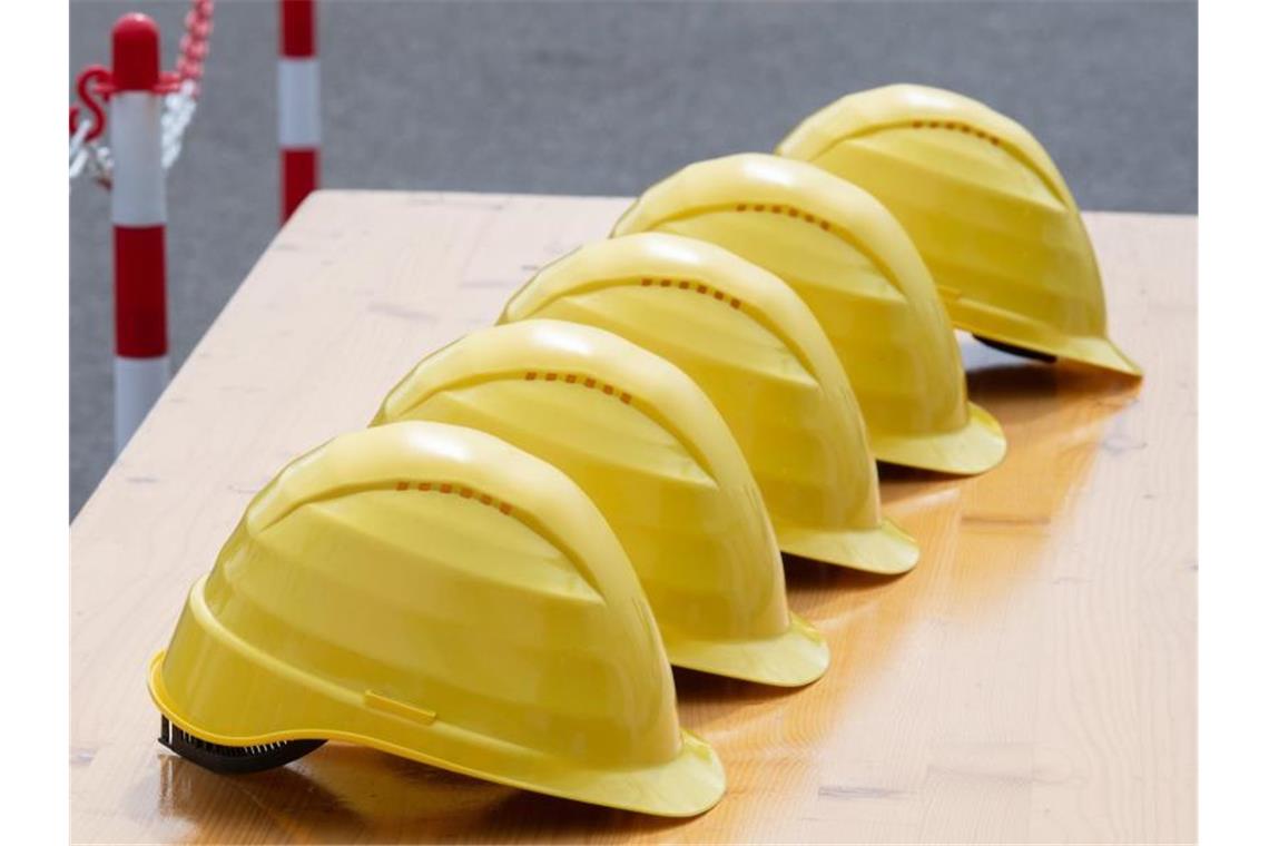 Gelbe Helme liegen nebeneinander. Foto: Soeren Stache/dpa/Symbolbild