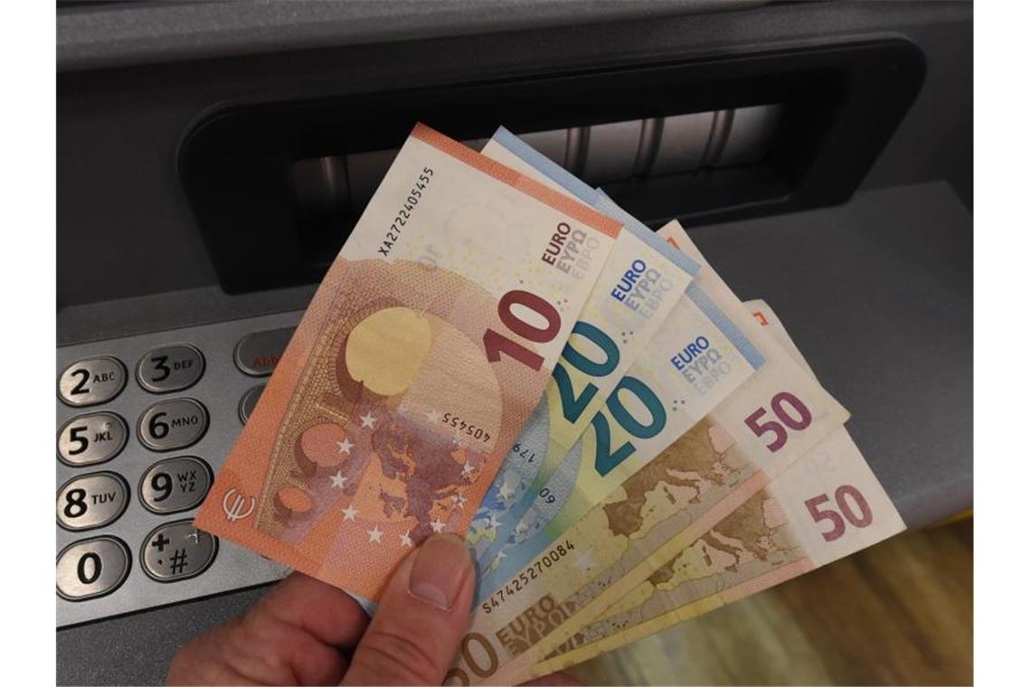Geldscheine werden an einem Geldautomaten abgehoben. Foto: Holger Hollemann/dpa