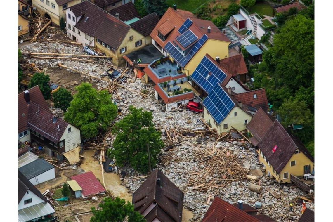 Geröll liegt im Mai 2016 nach einem Unwetter in einer Straße in Braunsbach (Baden-Württemberg). Foto: Christoph Schmidt/dpa