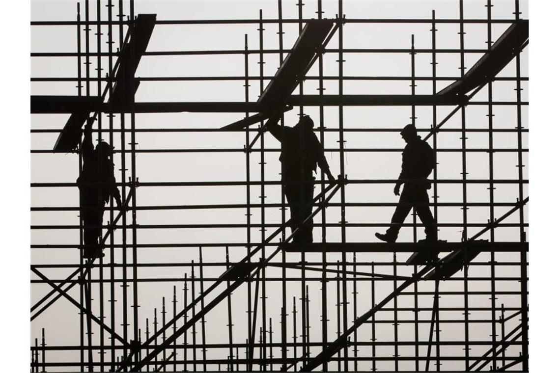 Niedriglöhne sind in Ostdeutschland besonders verbreitet Gerüstbauer errichten ein Gerüst. Immer mehr Menschen ohne Berufsabschluss landen in Deutschland im Niedriglohnbereich - vor allem in Ostdeutschland. Foto: picture alliance / Christian Charisius/dpa