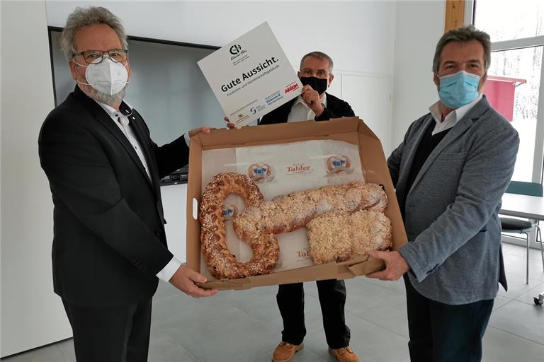 Geschäftsführender Vorstand Wolfgang Sartorius (links) und kaufmännischer Vorstand Bernd Messinger (rechts) übergeben mit einem symbolischen Schlüssel den Neubau an den Leiter der Sozialtherapie Klaus Engler. Foto: Erlacher Höhe