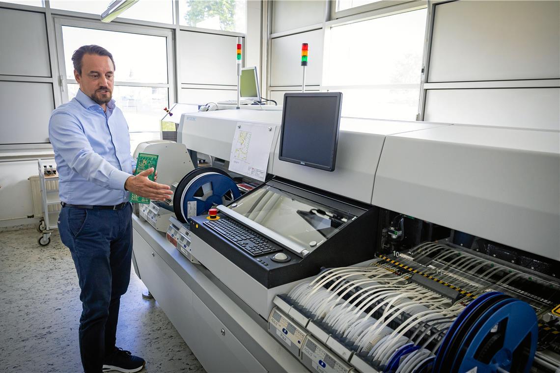 Geschäftsführer Sascha Hahn vor der SMD-Bestückungsmaschine, die von den Mitarbeitenden liebevoll „Emma“ getauft wurde. Foto: Alexander Becher