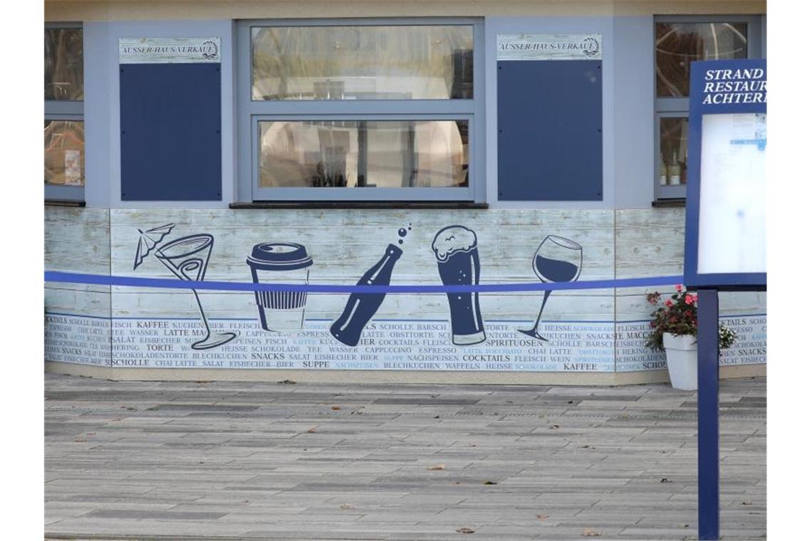 Geschlossen und mit einem Band abgesperrt ist ein Verkaufskiosk an der Promenade des Ostseebades. Foto: Bernd Wüstneck/dpa-Zentralbild/dpa