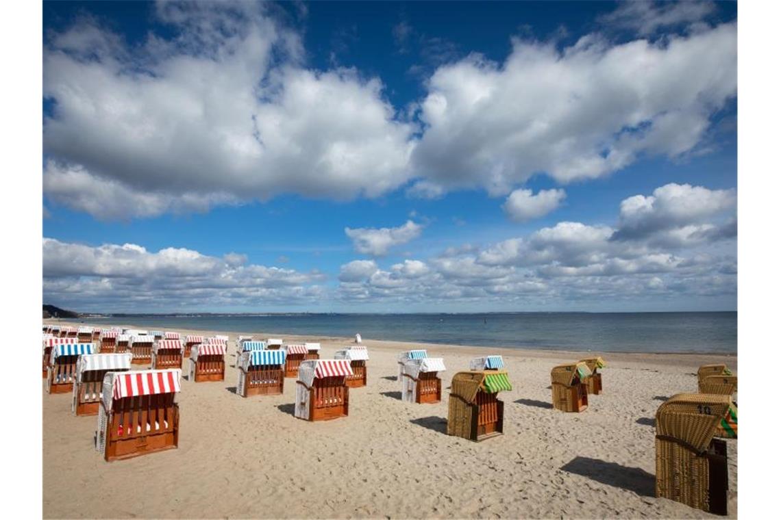 Tourismusbeauftragter optimistisch bei Sommerurlaub Geschlossene Strandkörbe stehen auf einem fast menschenleeren Strand an der Ostsee. Foto: Christian Charisius/dpa