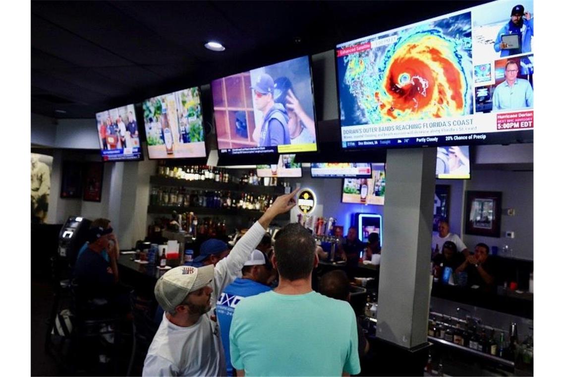 „Dorian“ hinterlässt auf Bahamas Todesopfer und Verwüstung Gesprächsthema: In einer Bar in Palm Beach beobachten Gäste das Herannahen des Hurrikans auf den TV-Bildschirmen. Foto: Richard Graulich/Palm Beach Post via ZUMA Wire