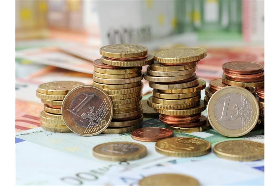 Gestapelte Geldmünzen liegen auf Geldscheinen. Foto: picture alliance / Tobias Hase/dpa/Symbolbild