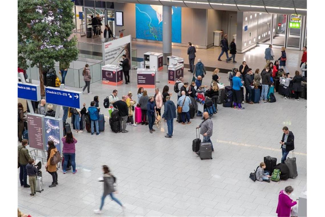 Gestrandete Fluggäste vor einem Serviceschalter am Flughafen Düsseldorf. Foto: Friso Gentsch/dpa