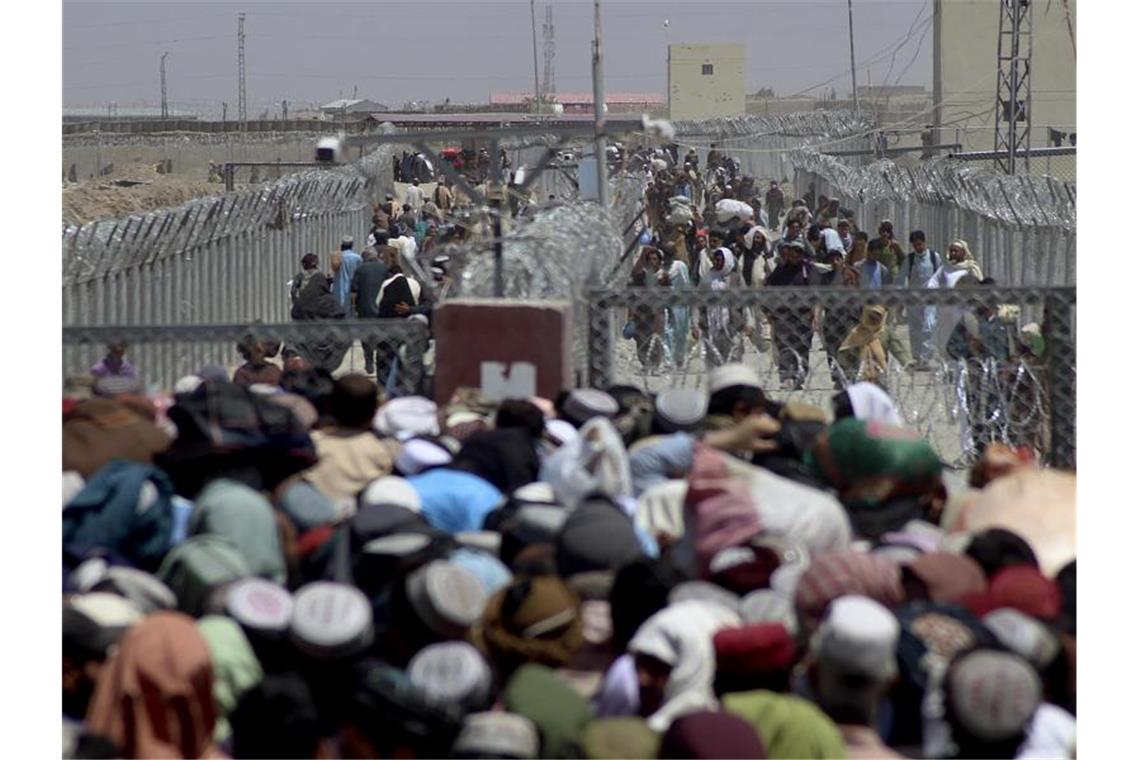 Gestrandete Menschen, die die Grenze zwischen Pakistan und Afghanistan überqueren. Pakistan hat seinen Grenzübergang Chaman zeitweilig geöffnet. Foto: Jafar Khan/AP/dpa