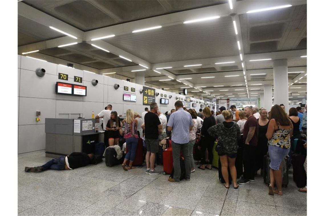 Gestrandete Urlauber stehen in einer Schlange am Flughafen von Palma de Mallorca. Foto: Isaac Buj/Europa Press