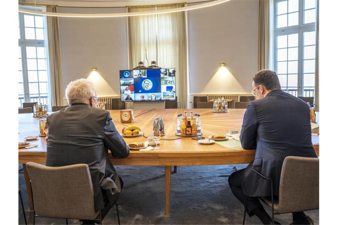 Gesundheitsminister Jens Spahn (r) und Baden-Württembergs Ministerpräsident Winfried Kretschmann bei einer Videokonferenz im Staatsministerium in Stuttgart. Foto: Jana Hoeffner/Staatsministerium Stuttgart/dpa