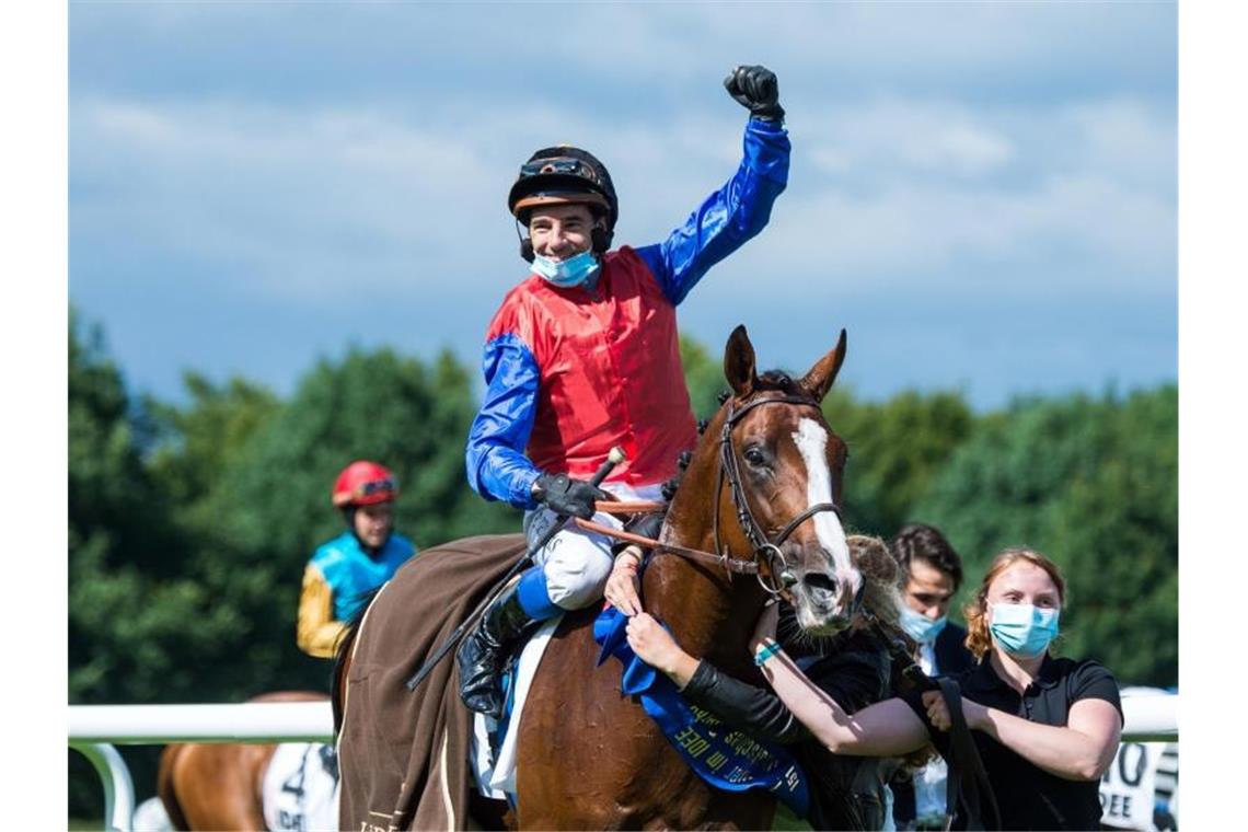 Gewannen das Deutsche Derby in Hamburg: Ronan Thomas jubelt auf dem Hengst In Swoop. Foto: Daniel Bockwoldt/dpa