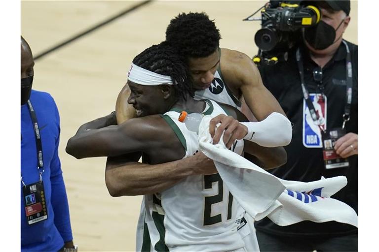 Giannis Antetokounmpo von den Milwaukee Bucks umarmt Teamkollege Jrue Holiday nach dem Sieg über die Suns. Foto: Ross D. Franklin/AP/dpa