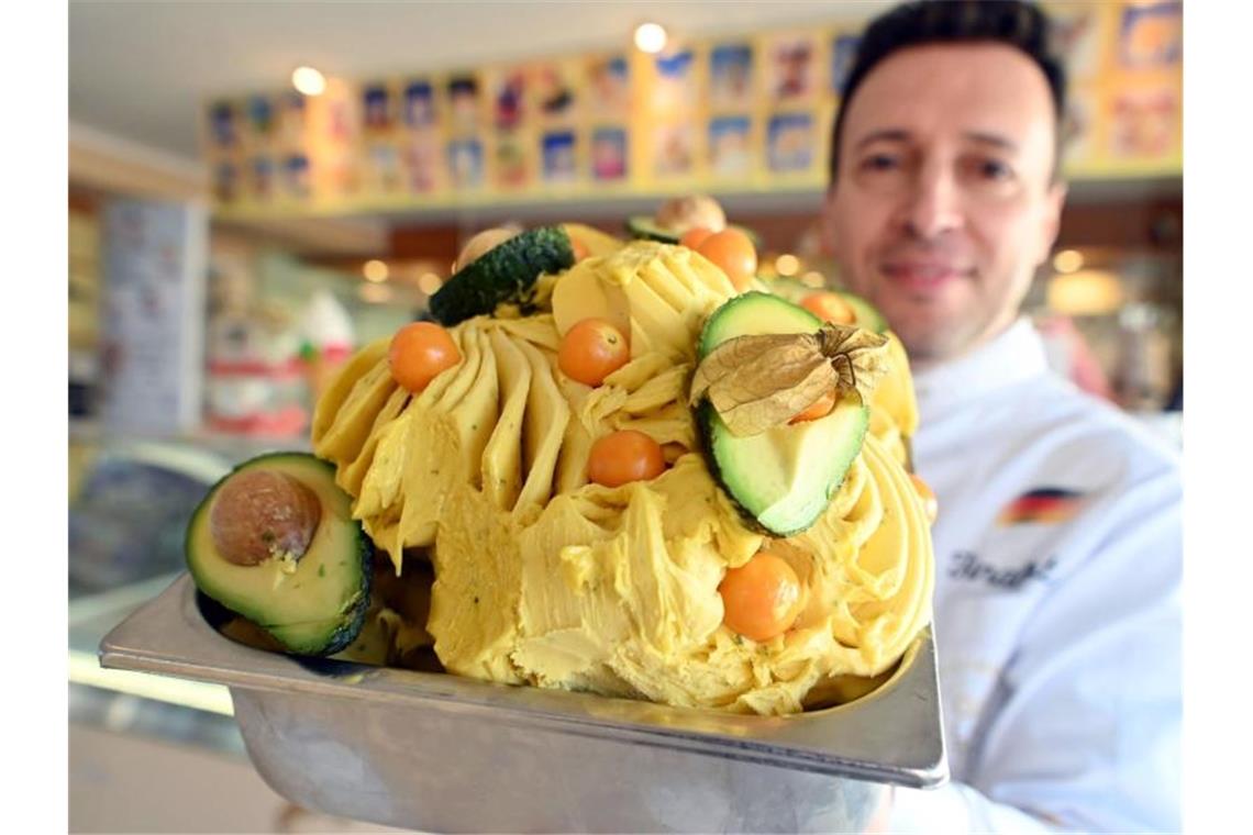 Giuseppe Cimino zeigt in seiner Eisdiele ein von ihm kreiertes Avocado-Physalis Sorbet Eis. Foto: Uli Deck/dpa/Archivbild