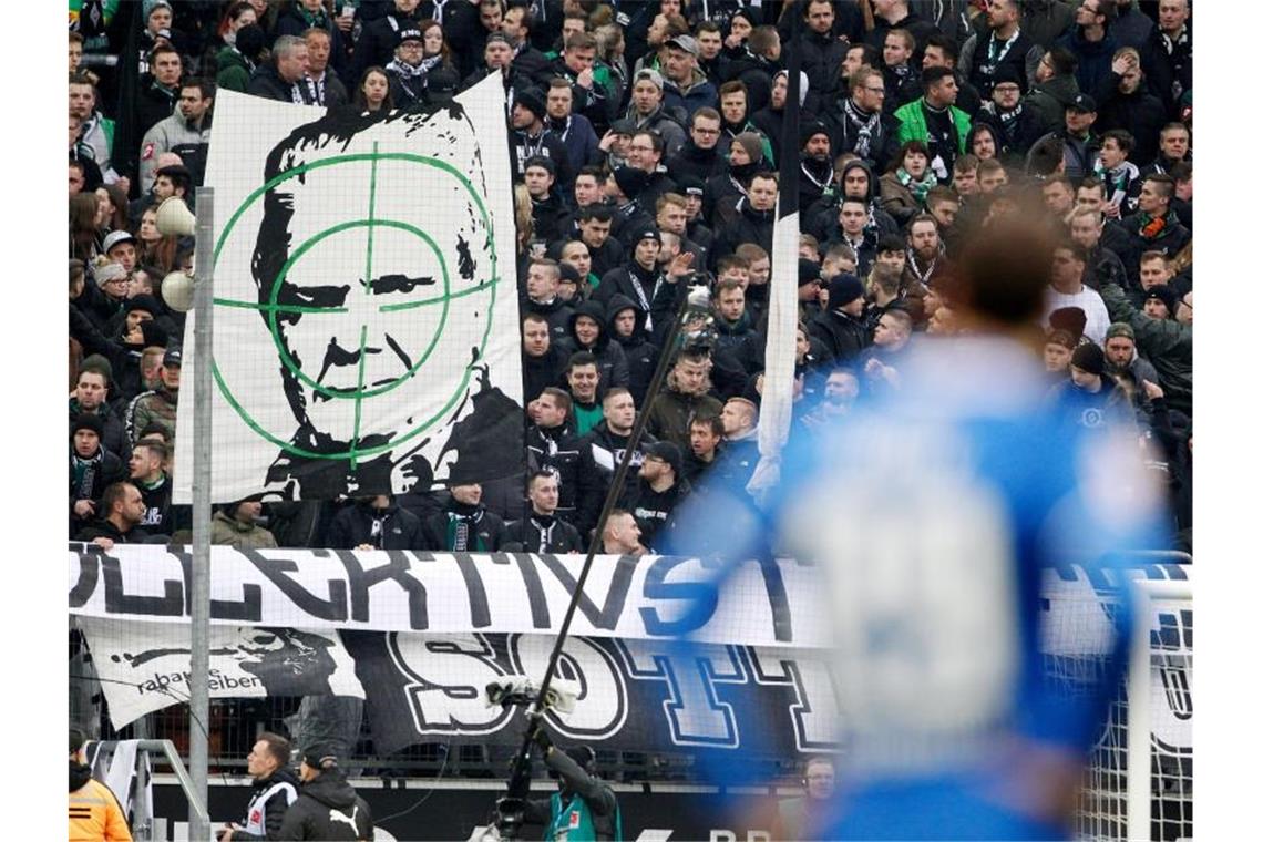 Gladbacher Fans zeigen ein Transparent mit dem Konterfei von Hoffenheim-Mäzen Dietmar Hopp. Foto: Roland Weihrauch/dpa