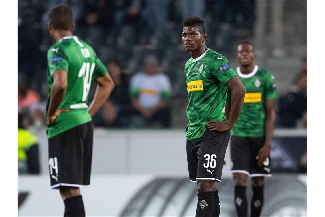 Gladbachs Alassane Plea (l-r), Breel Embolo und Denis Zakaria reagieren enttäuscht auf den Gegentreffer zum 0:4. Foto: Marius Becker