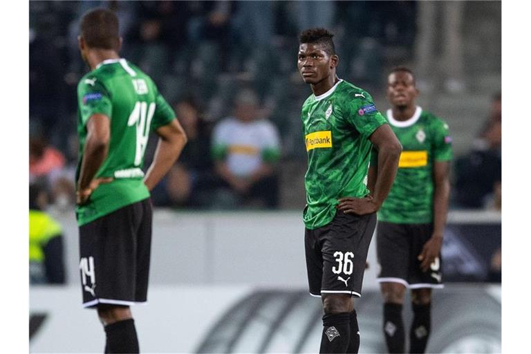 Gladbachs Alassane Plea (l-r), Breel Embolo und Denis Zakaria reagieren enttäuscht auf den Gegentreffer zum 0:4. Foto: Marius Becker