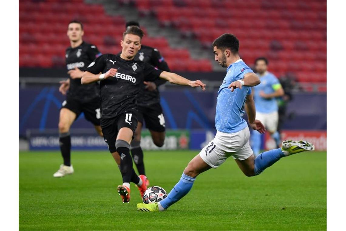 Gladbachs Hannes Wolf und Manchester Citys Ferran Torres (r) kämpfen um den Ball. Foto: Marton Monus/dpa