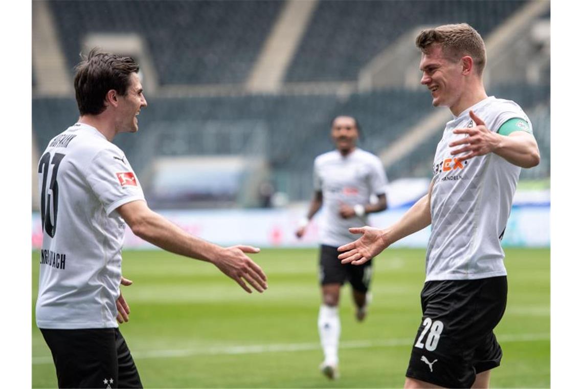 Gladbachs Jonas Hofmann (l) und Torschütze Matthias Ginter jubeln nach dem Treffer zum 1:0. Foto: Marius Becker/dpa