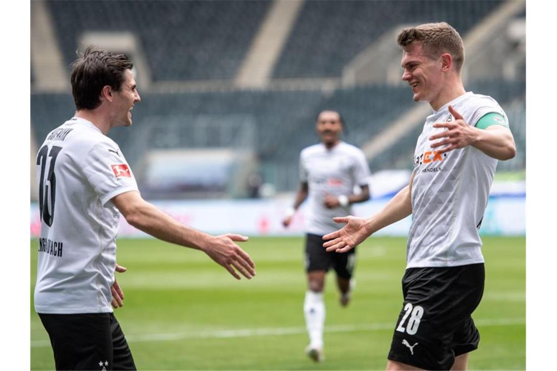 Bayern gewinnt in Wolfsburg - Flick kündigt Abschied an Gladbachs Jonas Hofmann (l) und Torschütze Matthias Ginter jubeln nach dem Treffer zum 1:0. Foto: Marius Becker/dpa