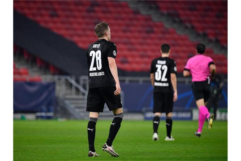 Gladbachs Matthias Ginter und Florian Neuhaus verlassen nach dem Abpfiff enttäuscht das Spielfeld. Foto: Marton Monus/dpa
