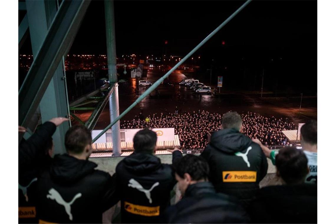 Gladbachs Spieler feiern nach dem Derbysieg gegen Köln mit ihren Fans vor dem Stadion. Foto: Fabian Strauch/dpa