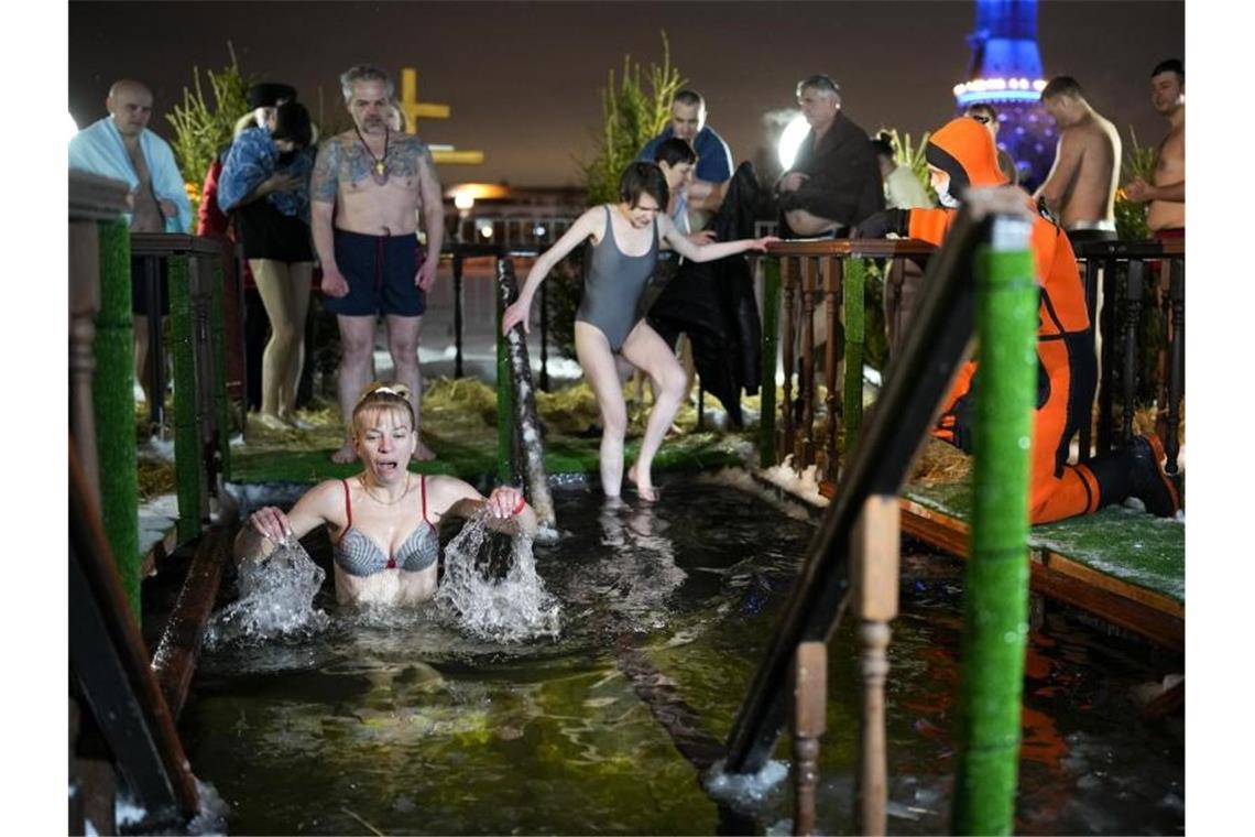 Millionen Menschen nehmen rituelles Eisbad Gläubige baden im eiskalten Wasser während des traditionellen Dreikönigsfestes in Moskau. Foto: Alexander Zemlianichenko/AP/dpa