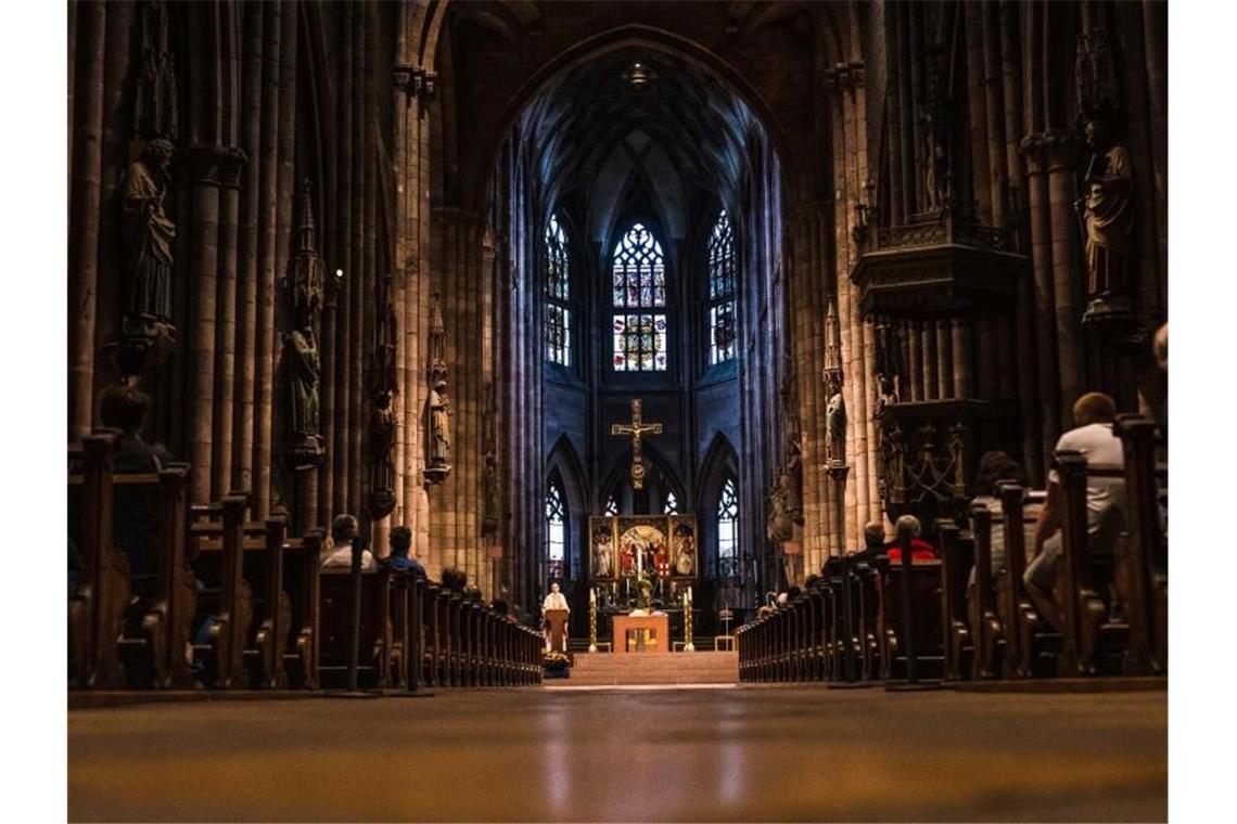 Kirchen müssen sparen: Millionenverluste wegen Corona Gläubige nehmen am Gottesdienst im Freiburger Münster teil. Foto: Philipp von Ditfurth/dpa/Archivbild