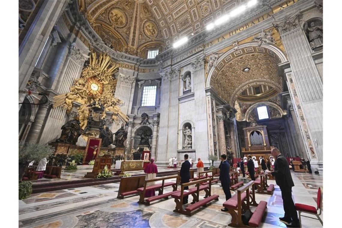 Gläubige nehmen an der von Papst Franziskus geleiteten Ostermesse im fast leeren Petersdom teil. Foto: Andreas Solaro/AFP/AP/dpa
