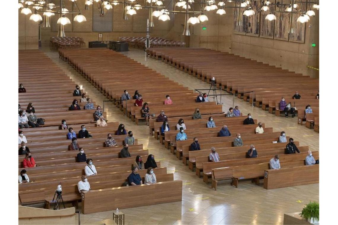 Gläubige sitzen mit Abstand voneinander in einer Kirche in Los Angeles. Kirchen müssen erstmal wieder ihren Betrieb einstellen. Foto: Damian Dovarganes/AP/dpa