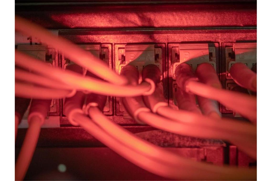 Glasfaserkabel führen zu einem Internet Switch in einem Serverraum. Foto: Michael Kappeler/dpa