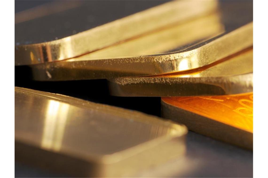 Goldbarren mit 100 Gramm Gewicht liegen auf einem Tisch. Foto: Armin Weigel/dpa
