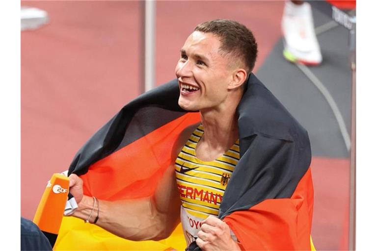 Goldmedaillengewinner Felix Streng jubelt nach dem Rennen mit der deutschen Fahne. Foto: Karl-Josef Hildenbrand/dpa