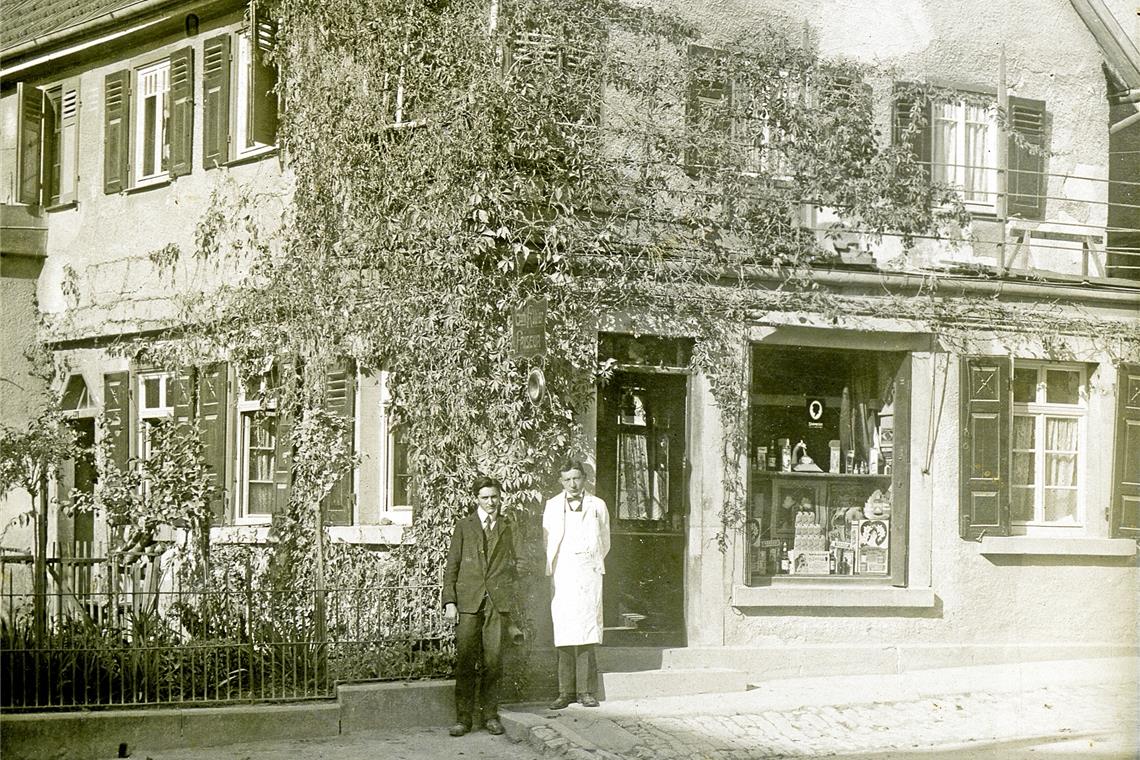 Gotthilf Kübler (rechts) vor seinem Friseurgeschäft um 1910.