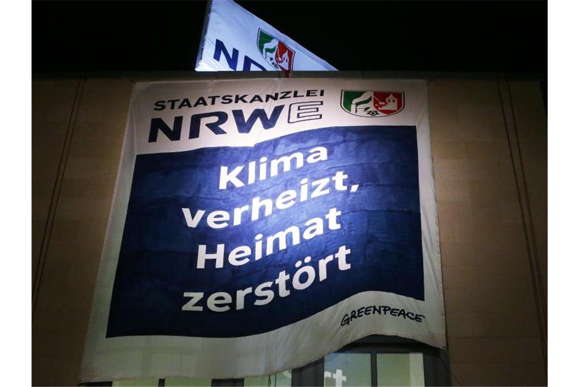 Greenpeace Aktivisten haben am Düsseldorfer Staatskanzlei zwei Banner aufgespannt. Auf dem Banner steht „Staatskanzlei NRWE: Klima verheizt, Heimat zerstört“. Foto: David Young/dpa