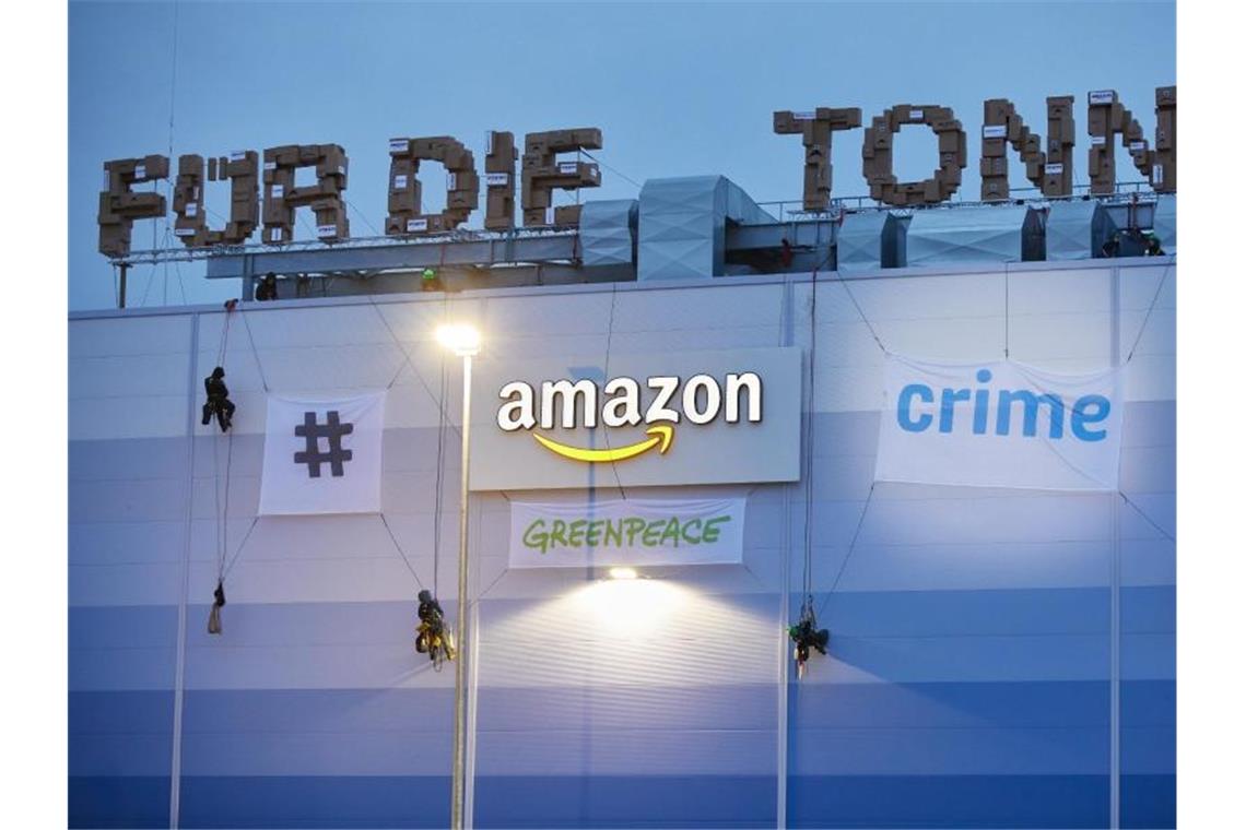 Greenpeace-Demonstranten beenden Protest auf Amazon-Lager Greenpeace-Aktivisten hängen am Gebäude der Amazon-Logistik Winsen Transparente auf. Foto: Georg Wendt