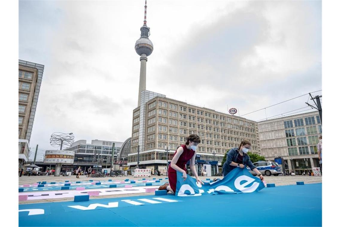Greenpeace mit Klima-Dialogtour durch 50 Städte Greenpeace-Aktivisten legen auf dem Alexanderplatz einen 25 Meter großen Chatverlauf als Bodenbanner. Foto: Fabian Sommer/dpa