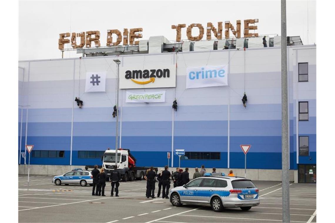Greenpeace-Aktivisten seilen sich am Gebäude der Amazon Logistik Winsen GmbH ab. Foto: Georg Wendt