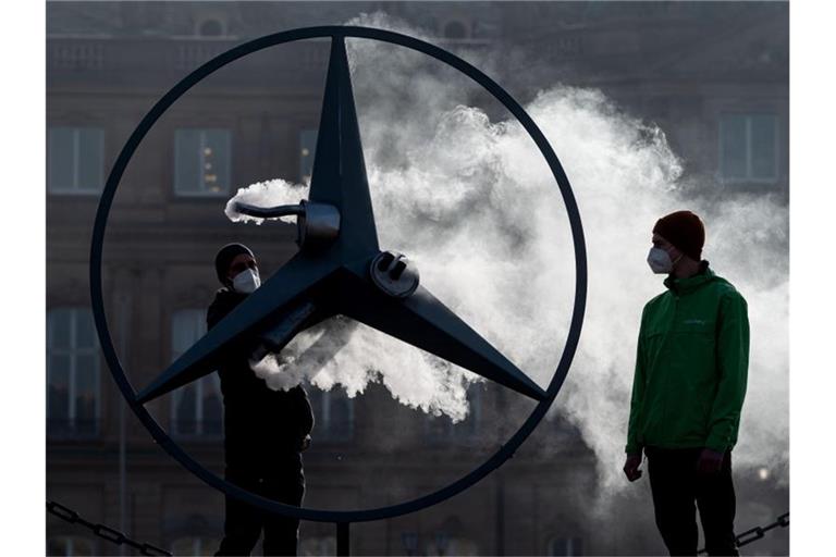 Greenpeace-Aktivisten stehen vor dem Neuen Schloss neben einem Mercedes-Stern. Foto: Marijan Murat/dpa