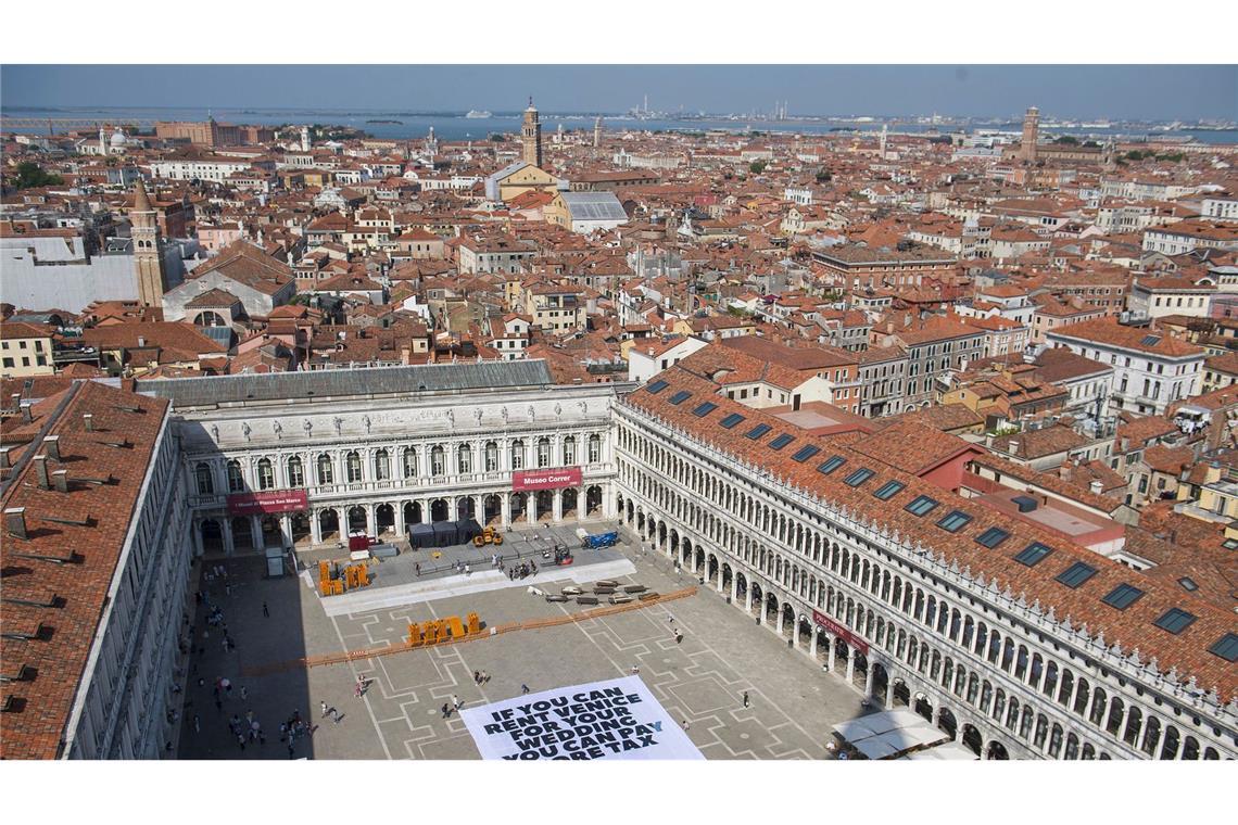 Krieg bringt Hochzeitspläne von Bezos durcheinander Greenpeace protestiert mit einem großen Transparent auf dem Markusplatz in Venedig gegen die Bezos-Hochzeit.