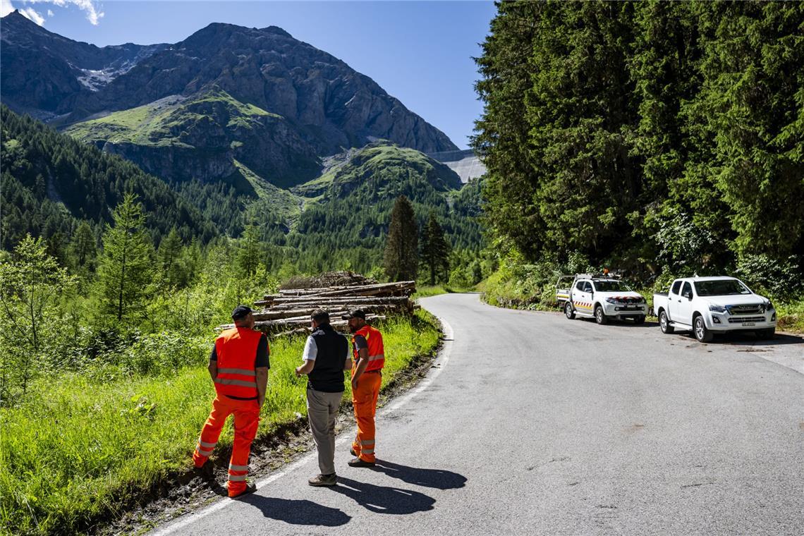 Gregory Logean, Präsident der Gemeinde Heremence, spricht mit Männern auf der gesperrten Straße vor der Staumauer Grande Dixence im Wallis.