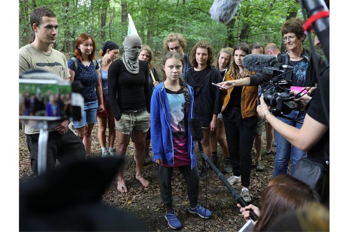 Greta Thunberg (M), Klimaschutzaktivistin, steht mit Aktivisten im Hambacher Forst. Foto: Oliver Berg/Archivbild