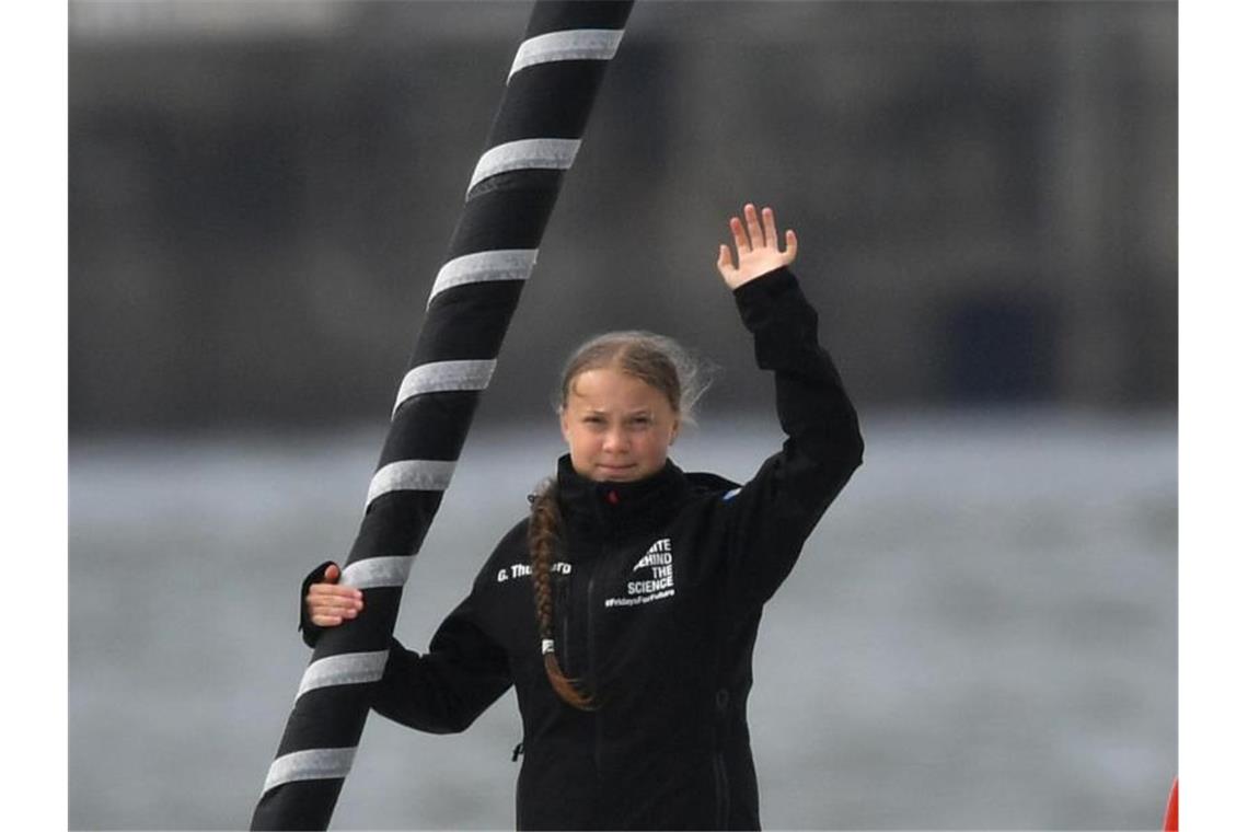 Greta Thunberg winkt von Bord der Hochseejacht „Malizia“. Foto: Ben Birchall/PA Wire