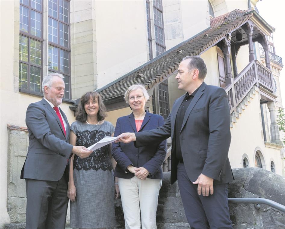 Große Freude bei Dekan Wilfried Braun, Pfarrerin Sabine Goller-Braun und der Kirchengemeinderatsvorsitzenden Ute Ulfert (von links). Der Backnanger Baudezernent Stefan Setzer überreicht persönlich die Baugenehmigung für die Generalsanierung der Stiftskirche. Foto: J. Fiedler