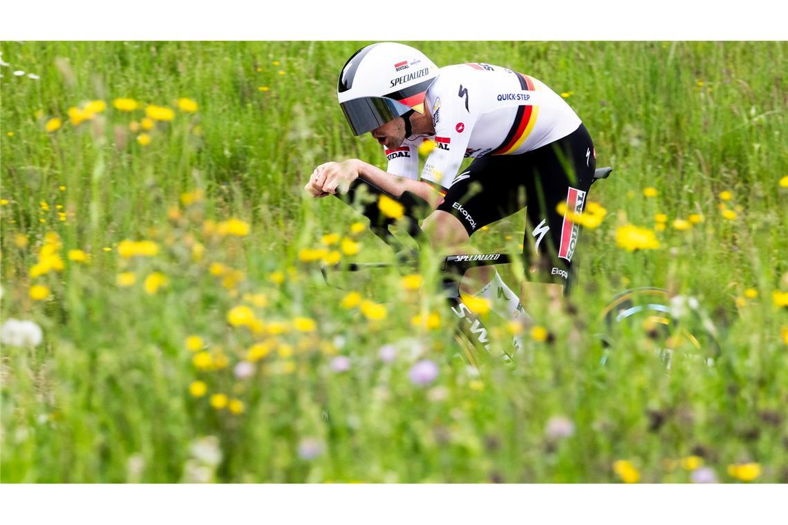 Grüner Sport: Maximilian Schachmann aus Deutschland fährt bei der Tour de Romandie durch blühende Wiesen.