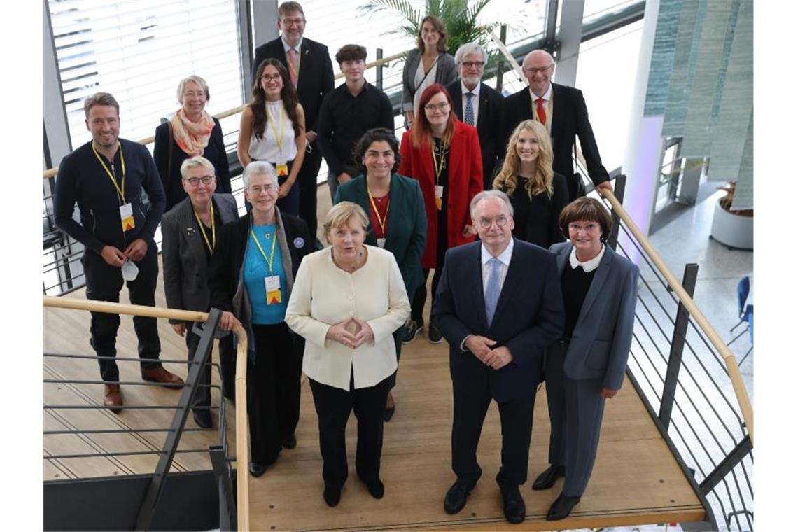 Gruppenbild mit den Einheitsbotschaftern: Bundeskanzlerin Angela Merkel und Ministerpräsident Reiner Haseloff. Foto: Jan Woitas/dpa POOL/dpa