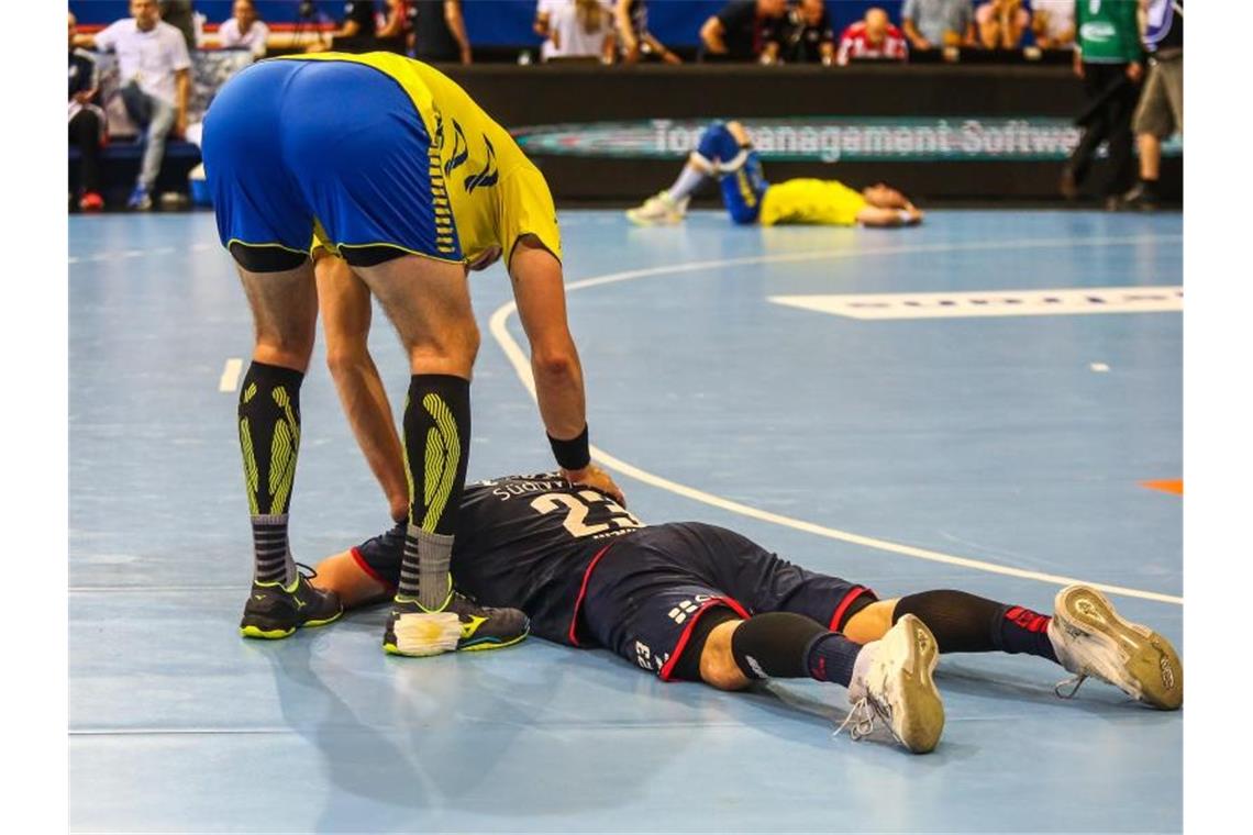 Herzschlagfinale: Flensburg jubelt, Gummersbach weint Gummersbachs Marvin Sommer tröstet nach Spielende Bietigheims Jan Asmuth. Beide Teams sind abgestiegen. Foto: Christoph Schmidt